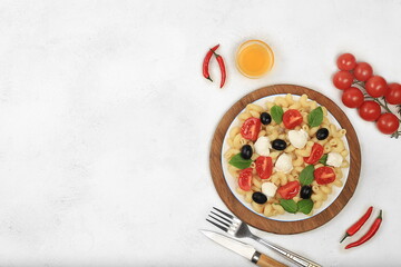 Italian cold pasta salad and caprese pasta, top view with space for text. Fusilli, tomatoes, mozzarella, olives and arugula salad with basil. Business card for menu, restaurant or cafe advertisement