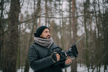 Director of photography with a camera in his hands on the set. Professional videographer at work on filming a movie, commercial or TV series