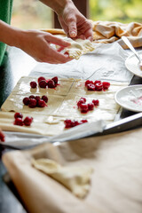 Mother cooking homemade cookies with cherry at home