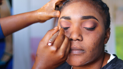 Close up of makeup artist applying makeup pencil on eye liner