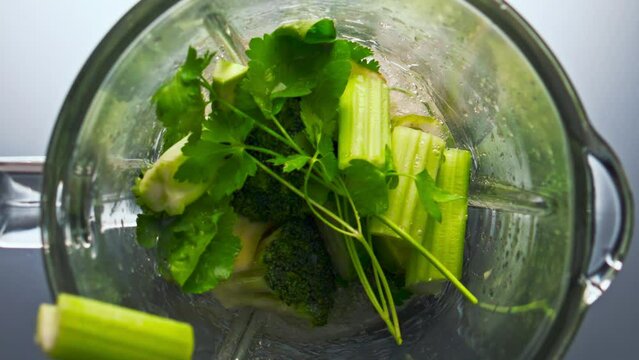Pieces vegetables inside blender preparing in super slow motion closeup.
