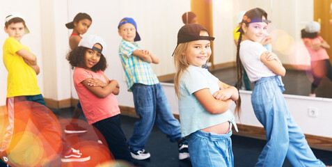 Smiling girls and boys hip hop dancers doing dance workout during group class
