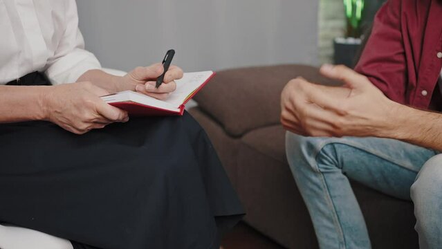 Patient talks to experienced psychologist sitting on sofa