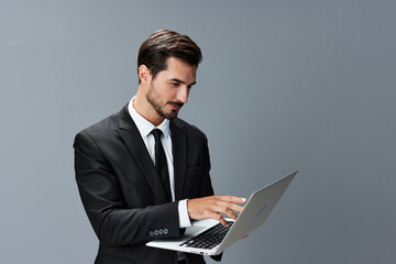 Man business tired stressed out looking at his laptop and working online via internet in business suit video call business talks on gray background copy place
