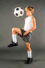 Young male soccer player bounces the ball off of his knee
