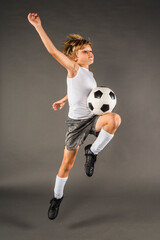 Young male soccer player jumps to trap the ball with his body