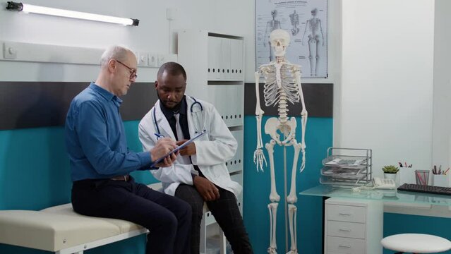 Elderly patient signing medical form at checkup visit with medic, doing healthcare examination to cure disease diagnosis. Using report to sign afte consultation appointment at health facility.