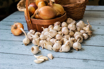 Fresh raw whole garlic and onions on wooden background