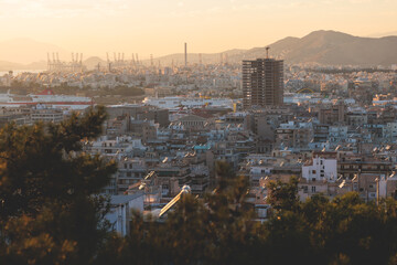 Obraz premium Piraeus city, Attica, beautiful panoramic view of Piraeus, Greece, with harbour and port, mountains and scenery beyond the city, seen from Prophet Helias Hill on Kastela Hill, sunset summer view