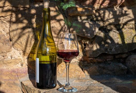 Tasting of red wine by old wine maker in Pierres Dor&eacute;es region with yellow stone houses on south of Beaujolais region, France