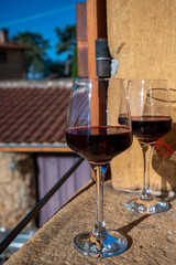 Tasting of red wine by old wine maker in Pierres Dorées region with yellow stone houses on south of Beaujolais region, France