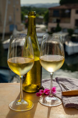 Drinking of cold white wine  with view on yacht harbour of Port Grimaud, summer vacation on French Riviera, France