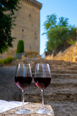 Glass of red dry wine and ruins of medieval castle of Châteauneuf-du-Pape ancient wine making village in France