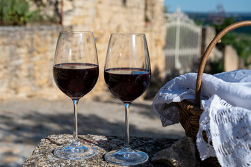 Glass of red dry wine and ruins of medieval castle of Châteauneuf-du-Pape ancient wine making village in France