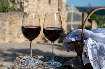 Glass of red dry wine and ruins of medieval castle of Châteauneuf-du-Pape ancient wine making village in France