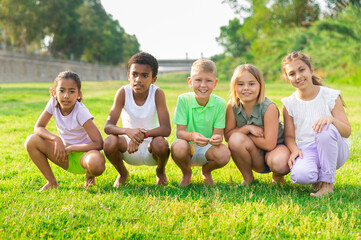 African-american and European children standing on grass outdoors.