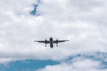 Fototapeta na wymiar Small propeller plane flying above the head before landing. Bottom of the plane on the sky