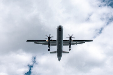 Small propeller plane flying above the head before landing. Bottom of the plane on the sky