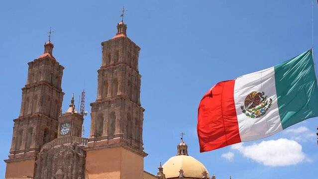 Mexican flag waving with Parroquia Cathedral Dolores Hidalgo Mexico, Cradle of National Independence Where Father Miguel Hidalgo made his Grito starting the 1810 War of Independence in Mexico