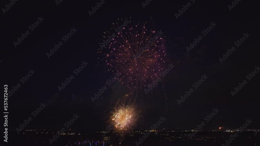 Wall mural aerial view of bright fireworks exploding with colorful lights over sea shore on us independence day