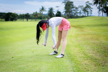 Portrait woman professional golfer under warm-up exercise stretching muscles before starting the...