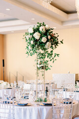 Flower arrangement centerpiece at a wedding reception. Beautiful table set up for wedding guests