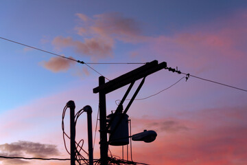 Silhouette of power poles in urban area of latin america city, attractive sky, showing technology and progress.