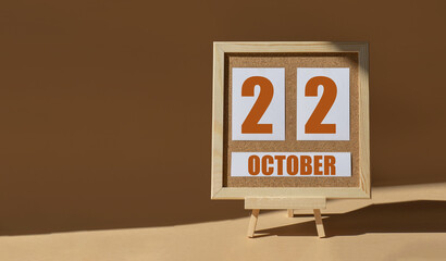 October 22th. Day 22 of month, Calendar date. Cork board, easel in sunlight on desktop. Close-up,...