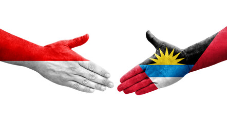 Handshake between Antigua and Barbuda and Indonesia flags painted on hands, isolated transparent image.