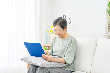 リビングでパソコンを使う高齢者女性