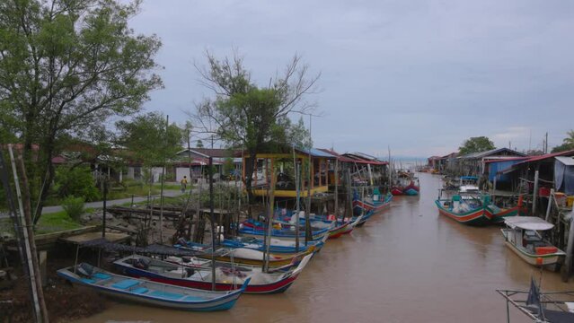 Fishing boats parked alongside fisherman village in Kuala Perlis, Malaysia.