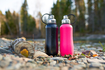 metal thermo bottle in the forest - obrazy, fototapety, plakaty