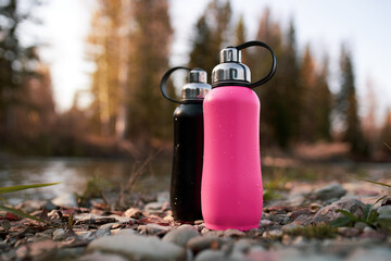 metal thermo bottle in the forest