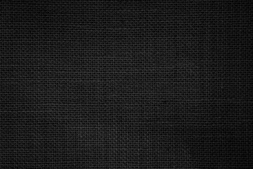 Fototapeta na wymiar Black fabric canvas texture background. Linen dyed black. Sackcloth woven texture pattern background dark.