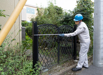 門扉を採寸をする作業員