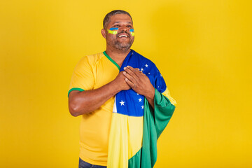 Brazilian black man, soccer fan from Brazil. with the hand on the chest, gratitude.