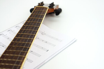 Acoustic guitar neck with music notes against white background. Love and music concept.