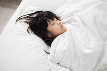 Obraz na płótnie Canvas asian kid sleep on bed, sick child
