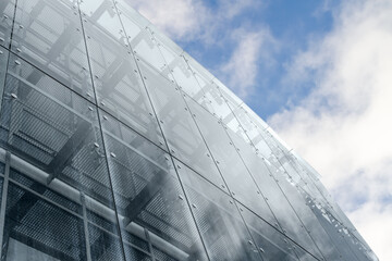 glass wall of modern office building on cloudy sky background