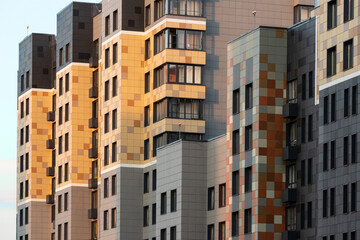 Fragment of multicolored facade of panel building with protruding architectural parts at sunset. Exterior architecture. Aerial view.