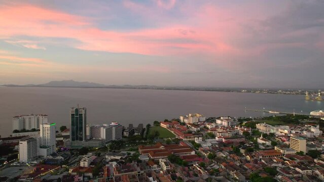 An amazing panoramic shot of beautiful Penang Island (Georgetown downtown area) in Malaysia seen from top of Penang Hill view point during warm and orange sunset. 4K