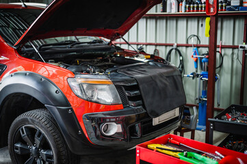 Orange pickup trucks maintenance and repair in garage services.