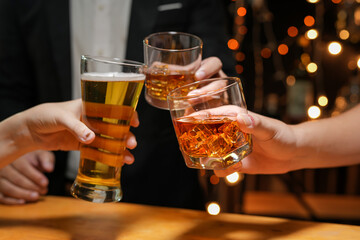 food and drink male friends are happy drinking beer and clinking glasses at a bar or pub.