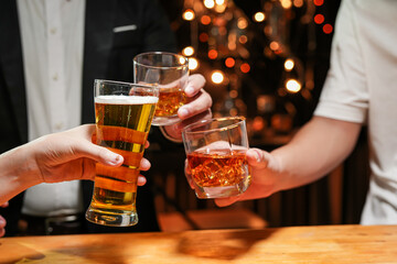 food and drink male friends are happy drinking beer and clinking glasses at a bar or pub.