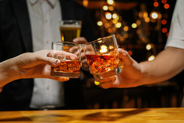 food and drink male friends are happy drinking beer and clinking glasses at a bar or pub.