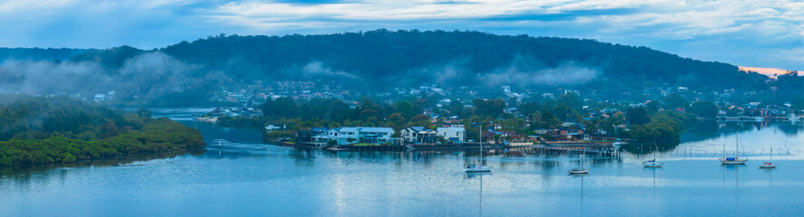 Naklejka premium Respite from the rain - Bay waterscape with mountain backdrop