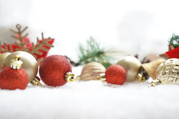 Christmas decoration. Christmas spruce with ball and blurred shiny lights. Christmas composition is with colorful balls on snow. Christmas decoration on snow with blur abstract background