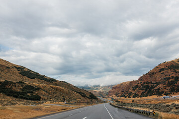 Highway among beautiful mountains. Beautiful road landscape with mountains and high sky with clouds. Echo Canyon, Utah 84017, USA - 08.02.2022