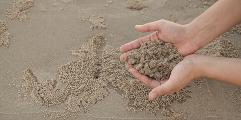 Close-up hand holding wet sand. Sand. Summer beach holiday vacation concept. A joyful time, happy by the beach with copy space. Environmental saving and  conservation background concept.