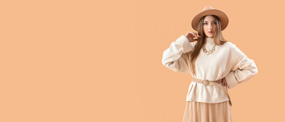 Beautiful fashionable young woman on beige background with space for text